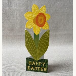 Upright daffodil shaped greetings card on neutral background