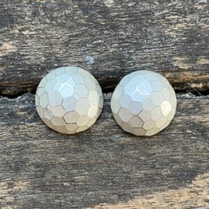 Silver domed earrings on a wooden background