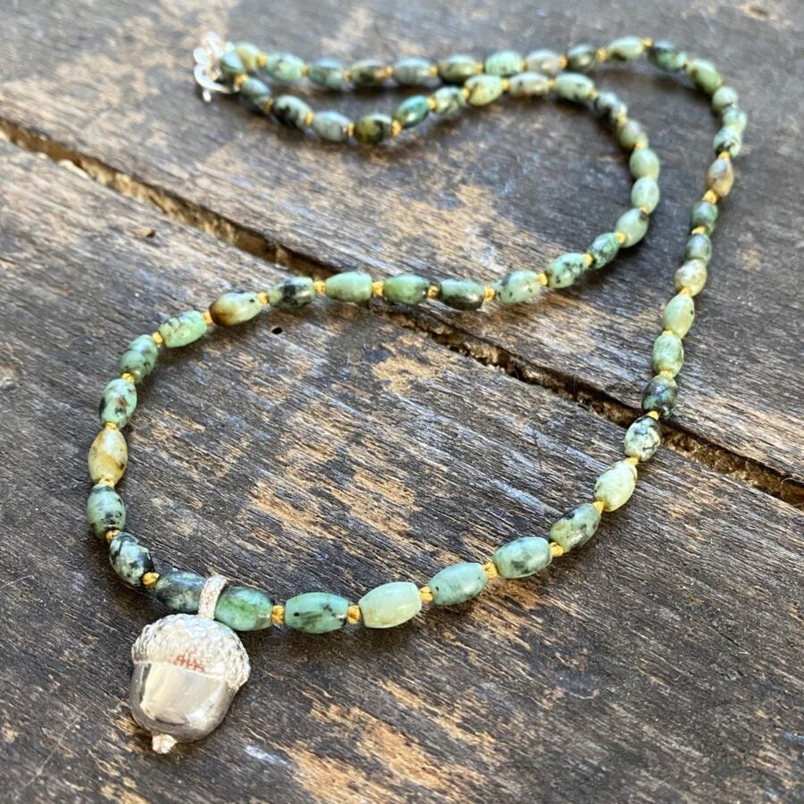 African turquoise gemstone necklace by Clare de la Torre on a wooden background