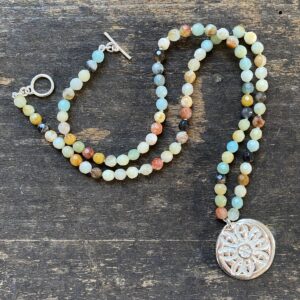 Silver and amazonite necklace by Clare de la Torre on a wooden background