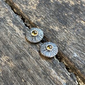 Silver disc earrings with citrine centre on a wooden background