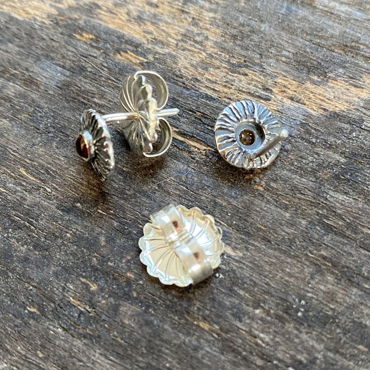 Silver disc earrings with citrine centre on a wooden background