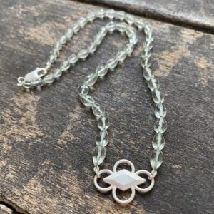 Amethyst & Silver beaded necklace on a wooden background