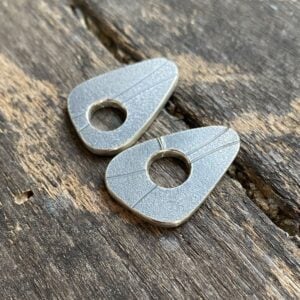 Silver earrings on wooden background