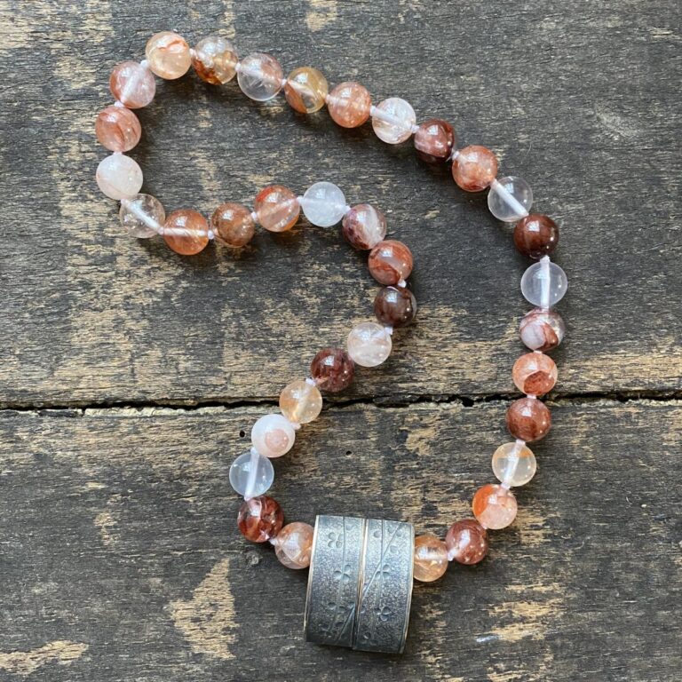 gemstone and Silver beaded necklace on a wooden background