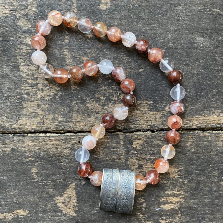 gemstone and Silver beaded necklace on a wooden background