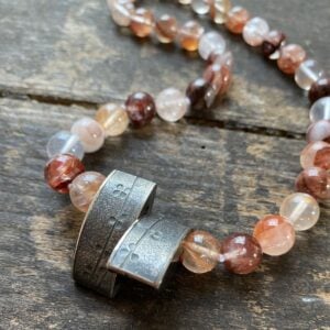 gemstone and Silver beaded necklace on a wooden background