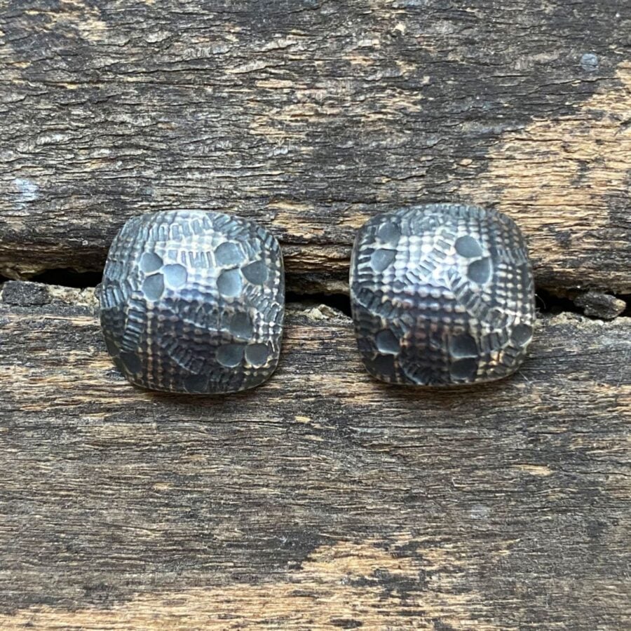 Silver earrings on wooden background