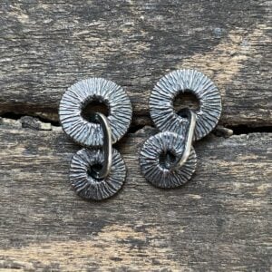 Silver earrings on wooden background
