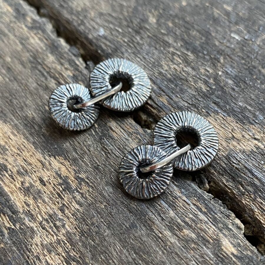 Silver earrings on wooden background