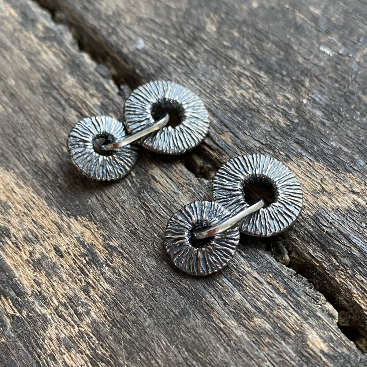 Silver earrings on wooden background