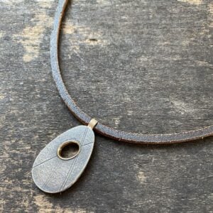 Silver pendant necklace on a wooden background