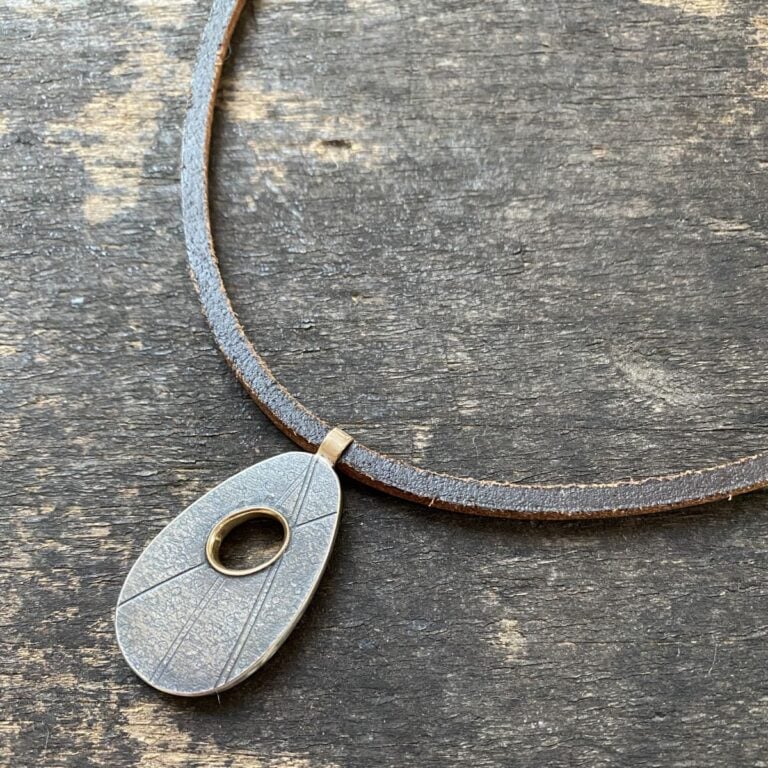 Silver pendant necklace on a wooden background