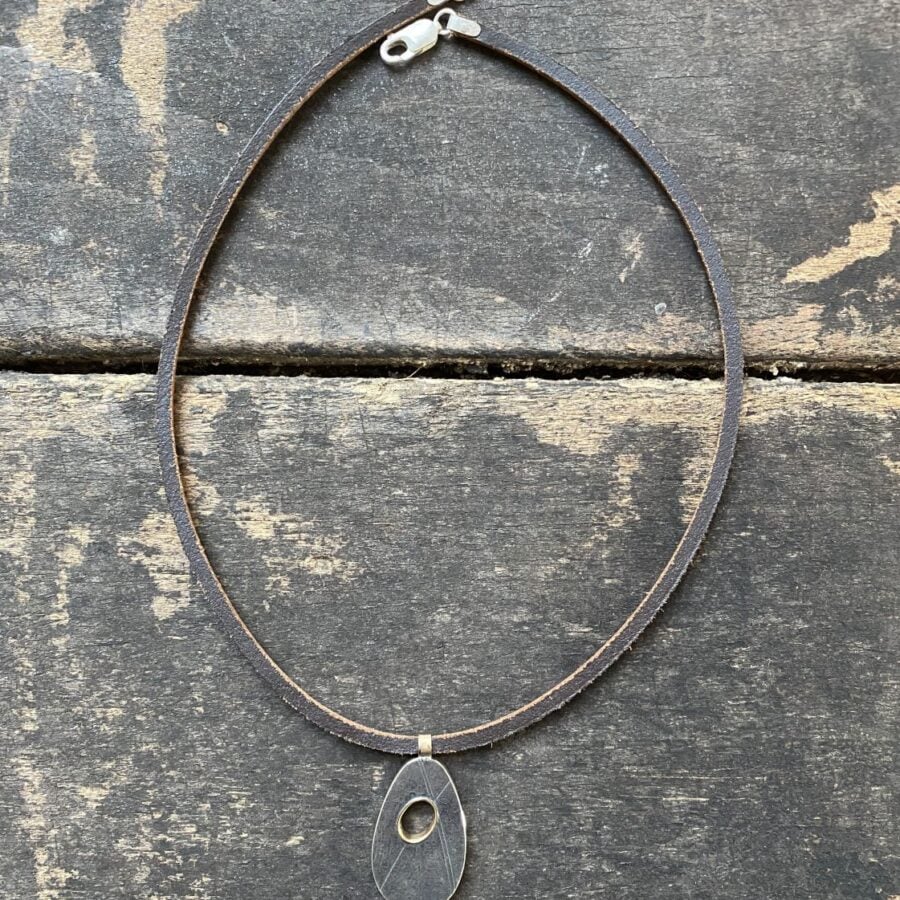 Silver pendant necklace on a wooden background