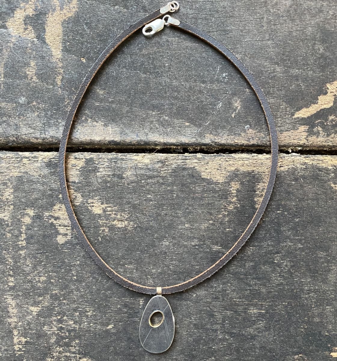 Silver pendant necklace on a wooden background