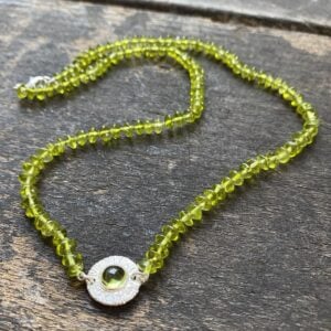 Peridot bead necklace on a wooden background