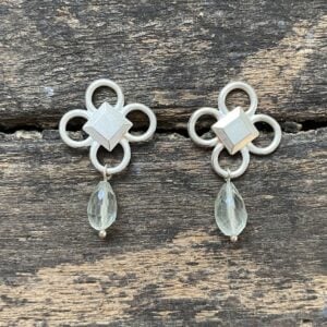 Silver drop earrings on wooden background