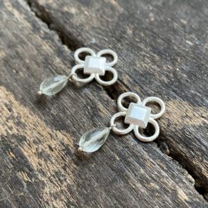 Silver drop earrings on wooden background