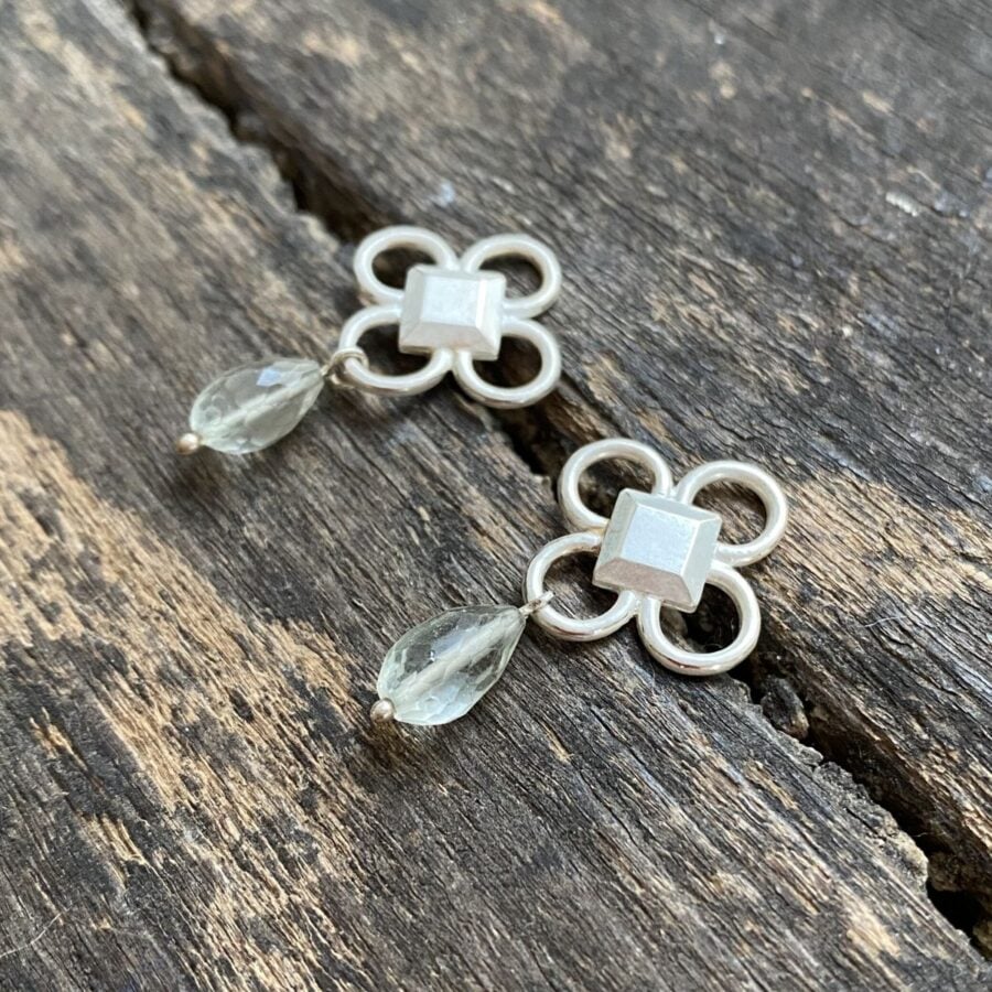 Silver drop earrings on wooden background