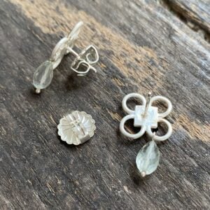 Silver drop earrings on wooden background