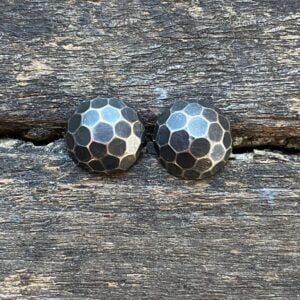 Silver domed earrings on a wooden background