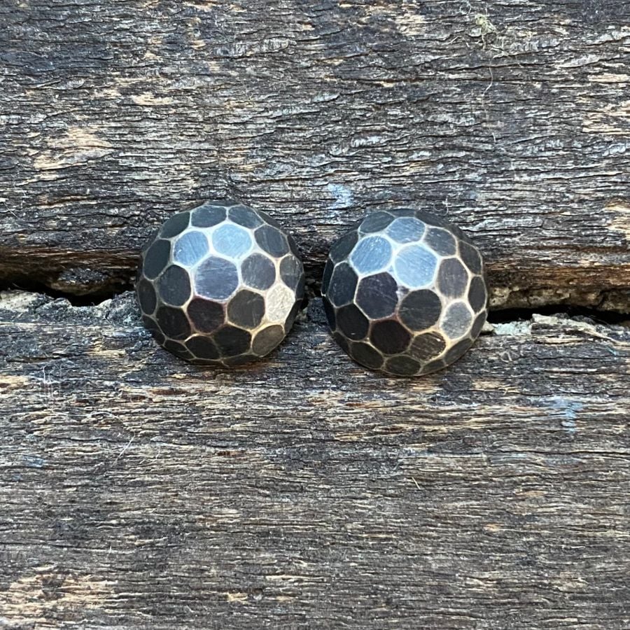Silver domed earrings on a wooden background
