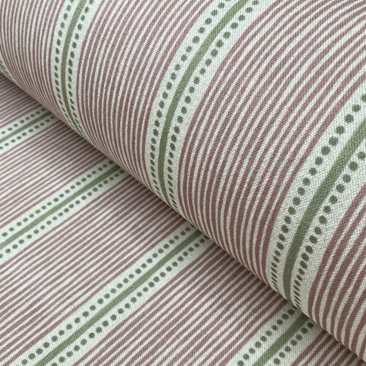 Pink & Green striped fabric on a roll at an angle