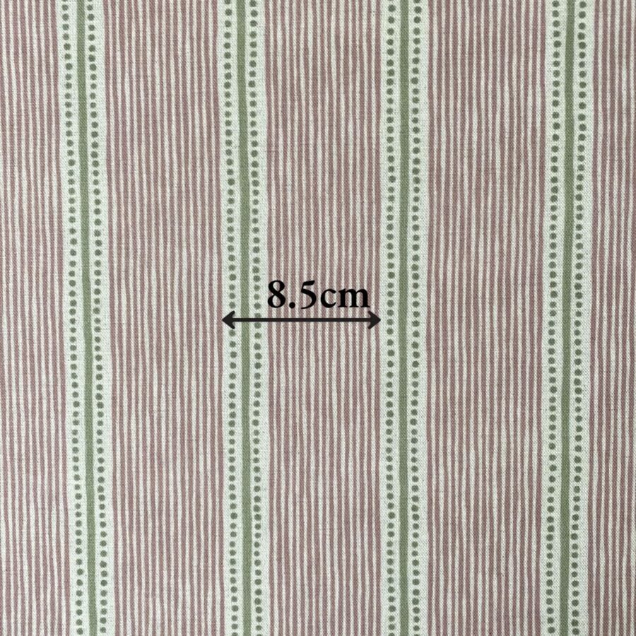 Pink & Green striped fabric on a roll at an angle
