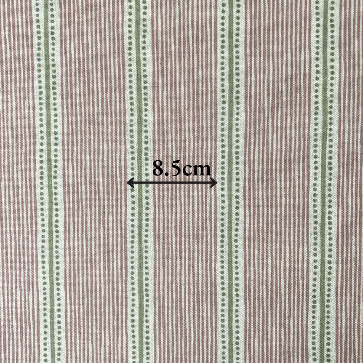 Pink & Green striped fabric on a roll at an angle