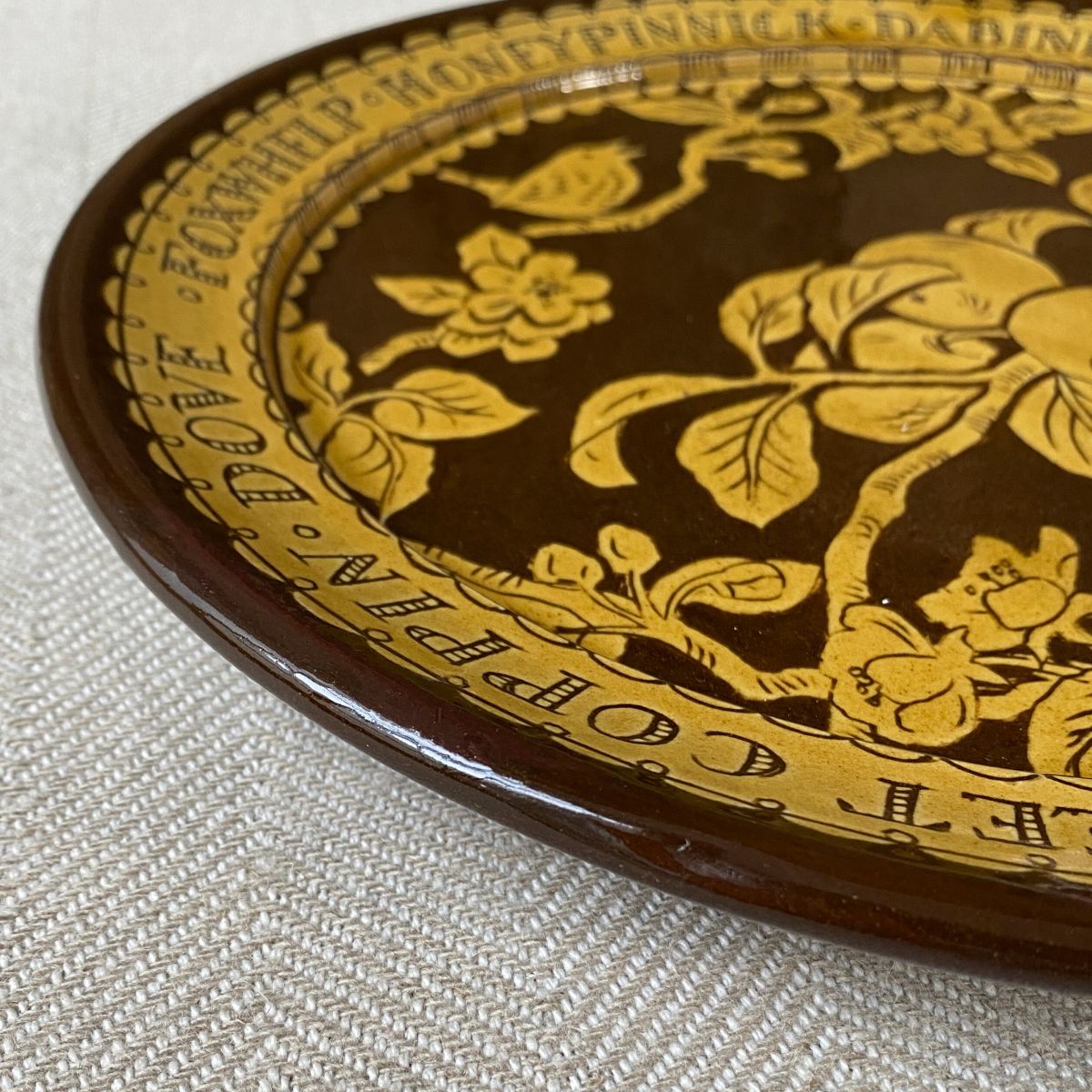 Detail of a Katie B Morgan slipware Plate on a tablecloth