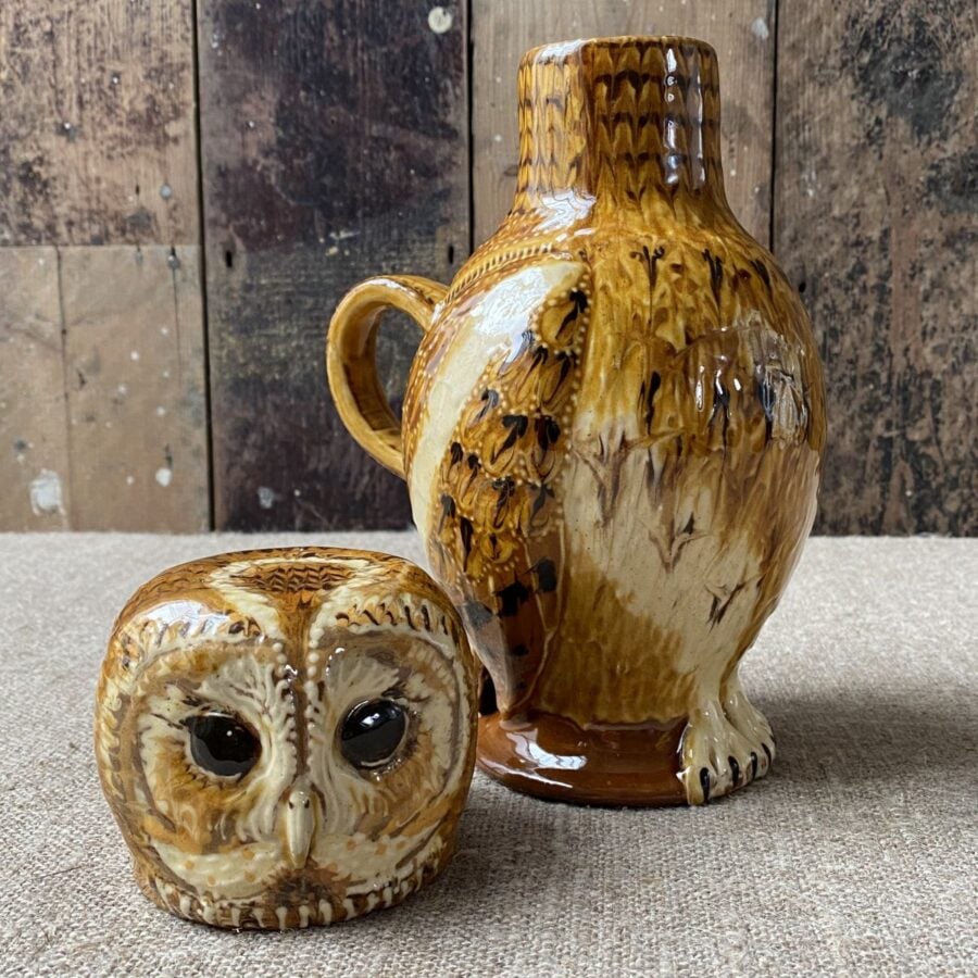 Carole Glover slipware glazed Owl Jug against a wooden background