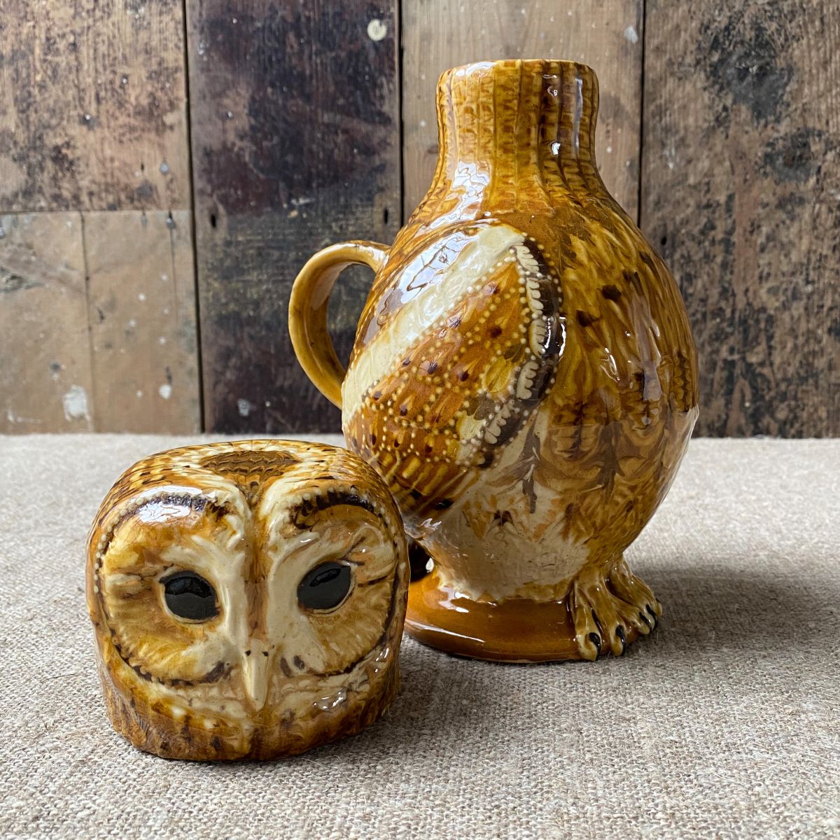 Carole Glover slipware glazed Owl Jug against a wooden background