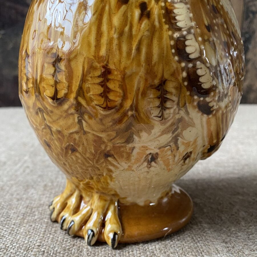 Carole Glover slipware glazed Owl Jug against a wooden background