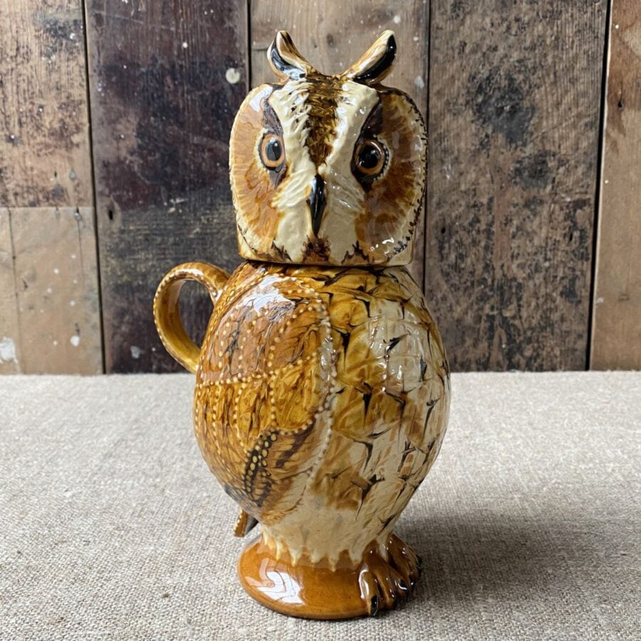Carole Glover slipware glazed Owl Jug against a wooden background