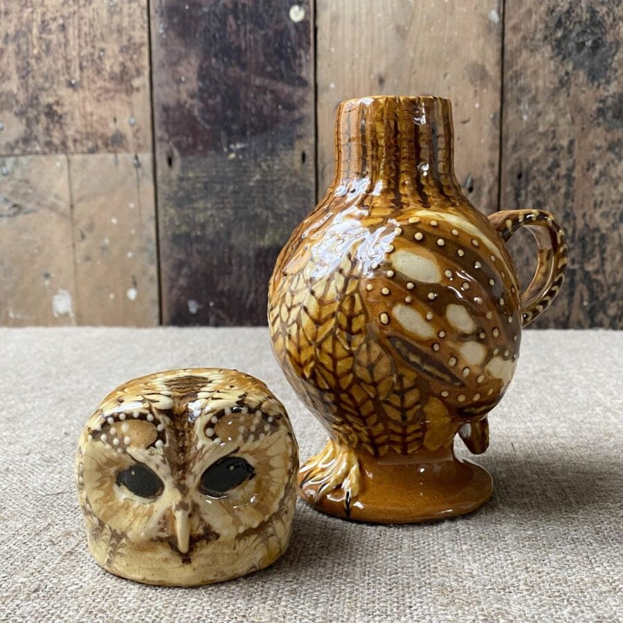 Carole Glover slipware glazed Owl Jug against a wooden background