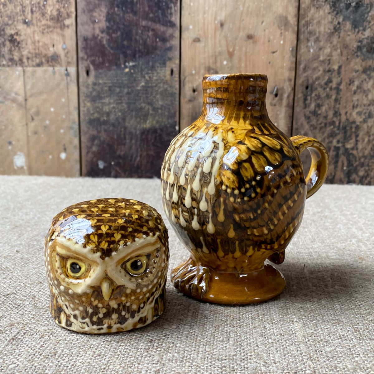 Carole Glover slipware glazed Owl Jug against a wooden background