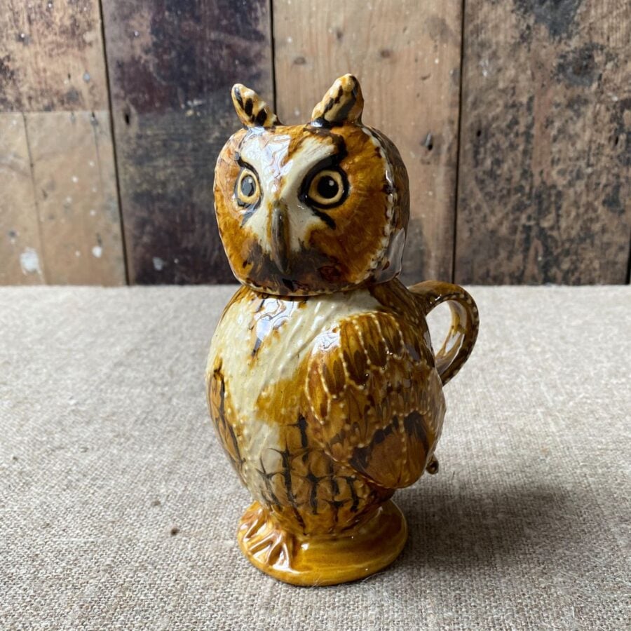 Carole Glover slipware glazed Owl Jug against a wooden background