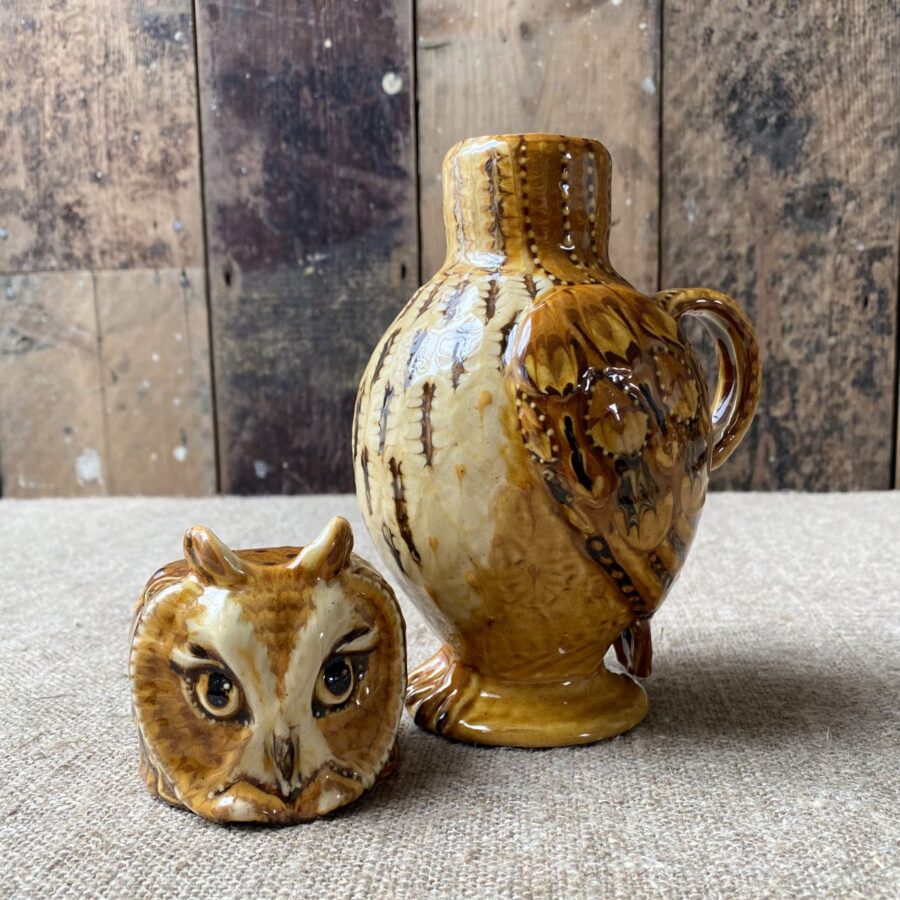 Carole Glover slipware glazed Owl Jug against a wooden background