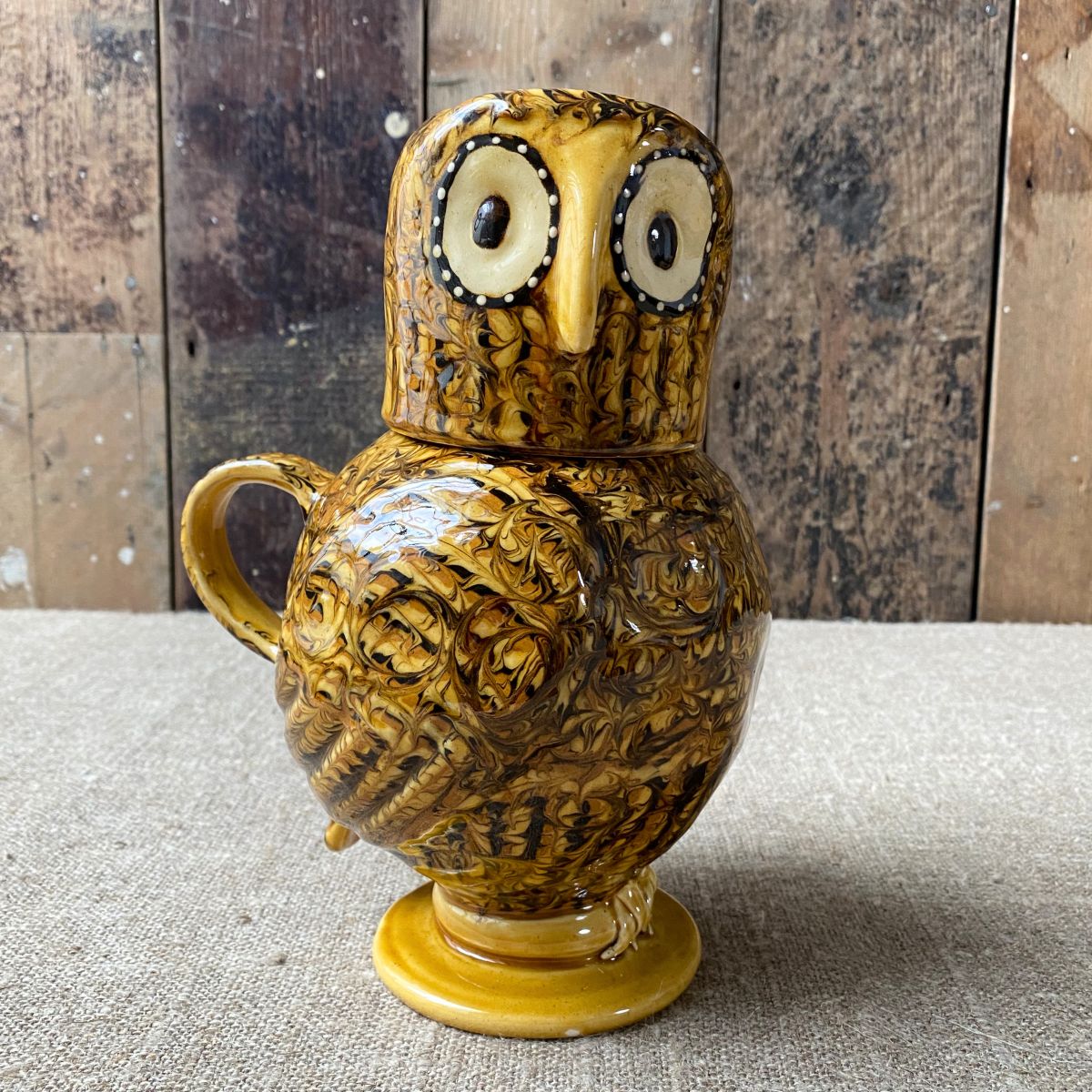 Carole Glover slipware glazed Ozzy Owl against a wooden background