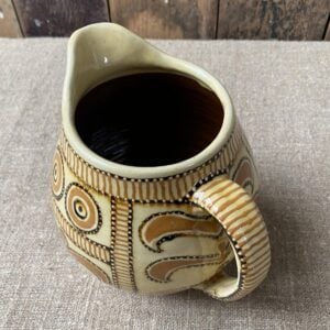 Top View Carole Glover Slipware Noggin Jug against wooden background