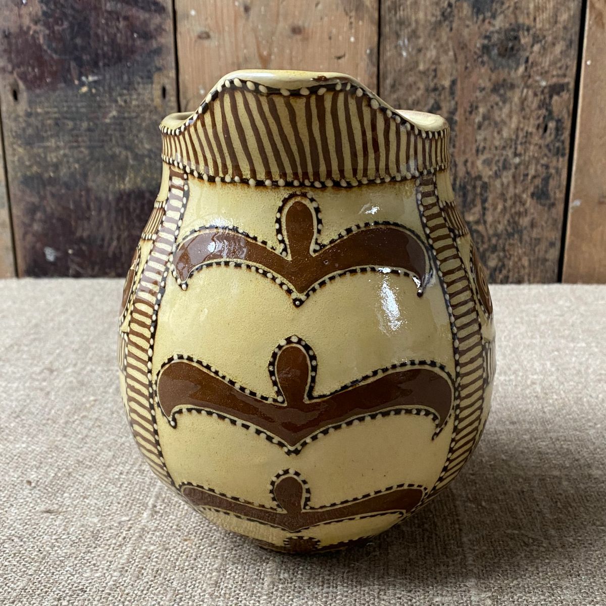 Front View Carole Glover Slipware Noggin Jug against wooden background