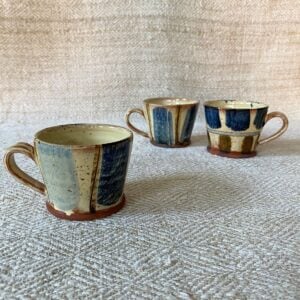 Jennifer Hall trio of slipware glazed espresso mugs on a cream textile background