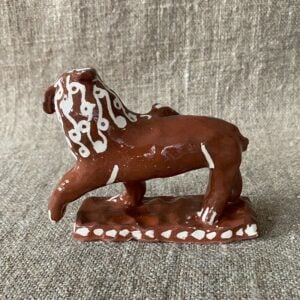 Emma Carlow upright lion pottery whistle against fabric background