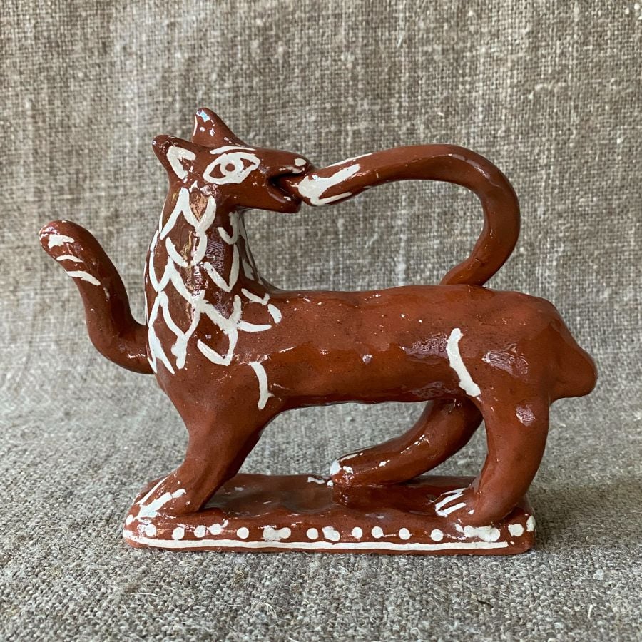 Emma Carlow tail-biting lion pottery whistle against fabric background