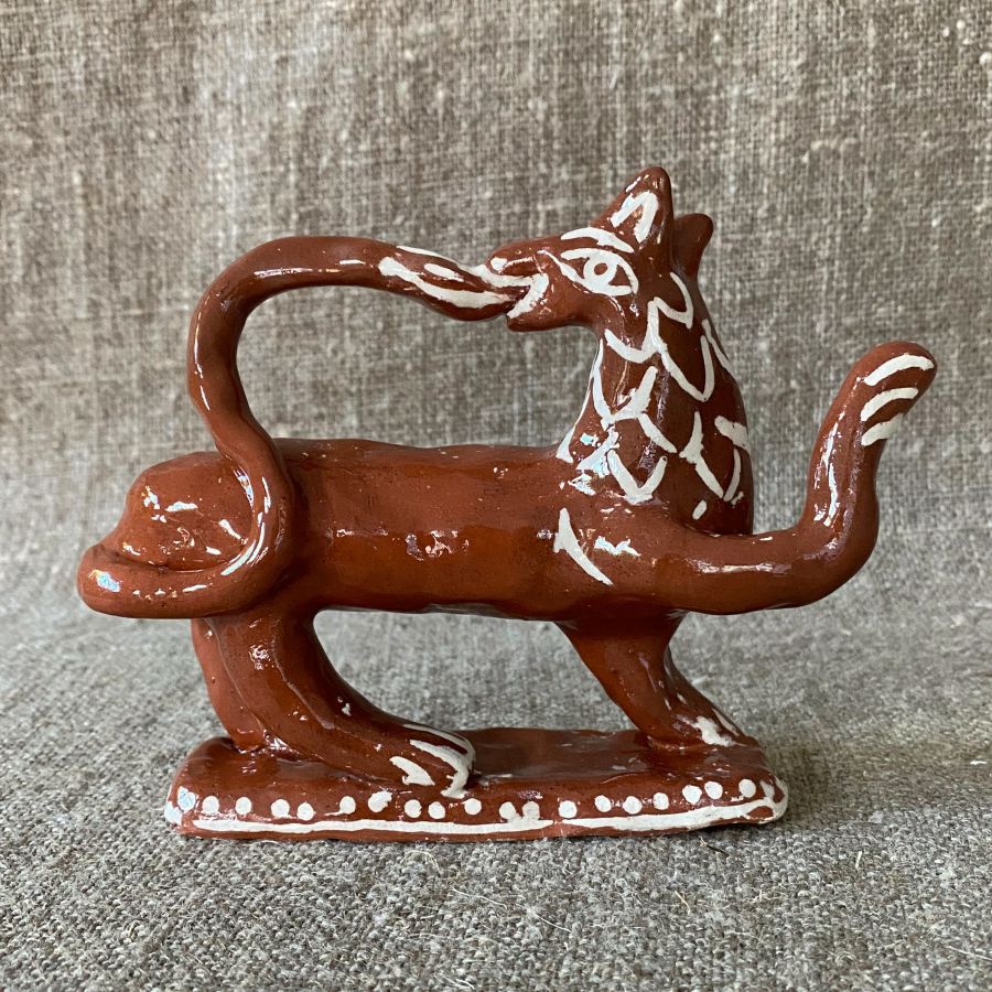 Emma Carlow tail-biting lion pottery whistle against fabric background