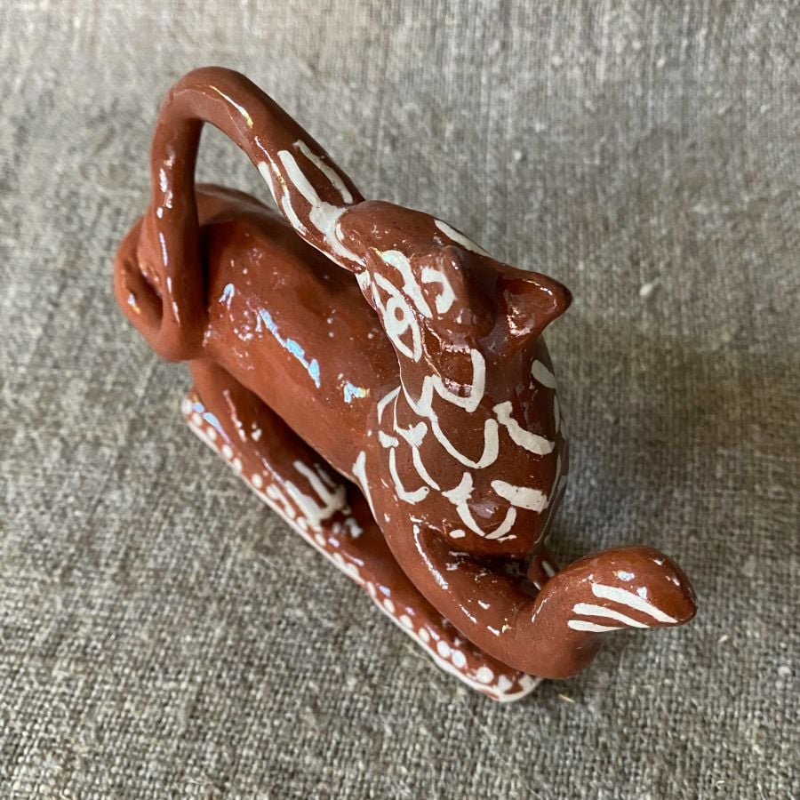 Emma Carlow tail-biting lion pottery whistle against fabric background