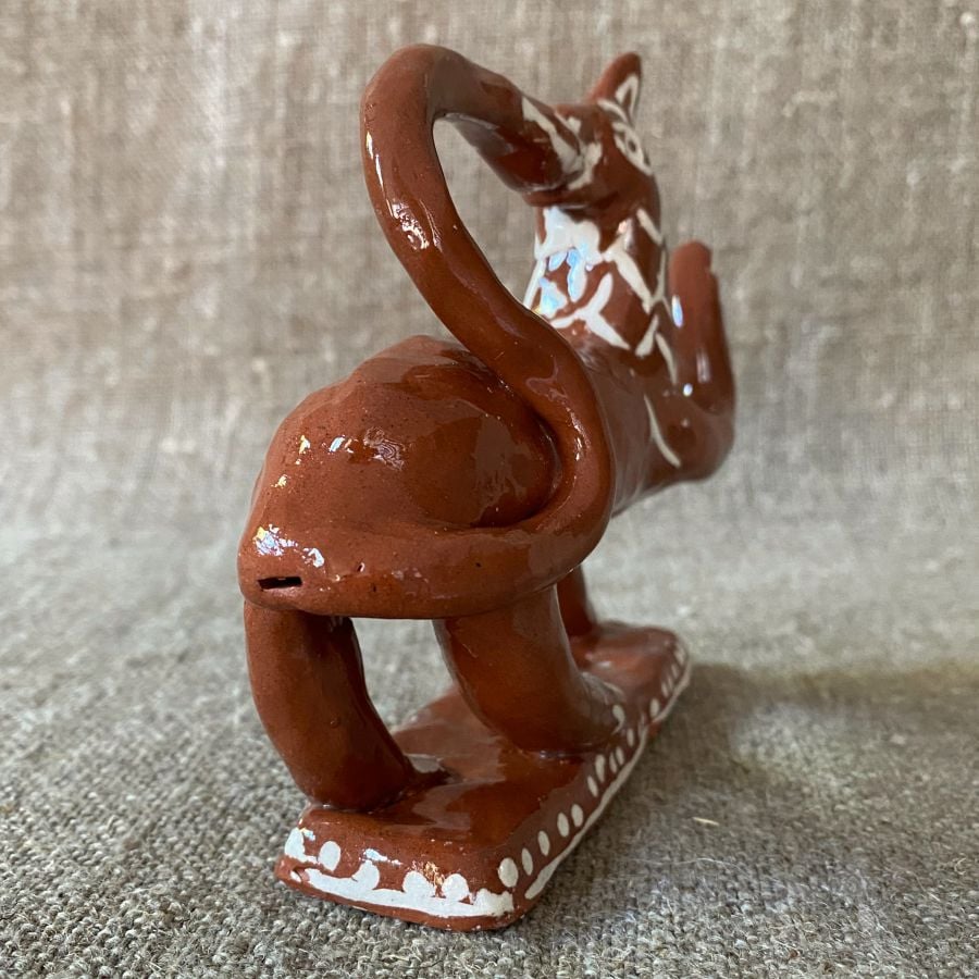 Emma Carlow tail-biting lion pottery whistle against fabric background