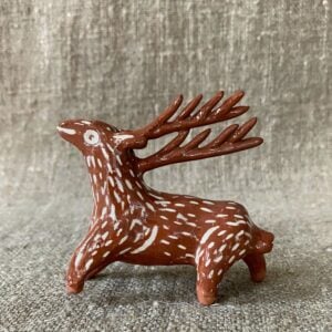 Emma Carlow pottery whistle in the shape of a reindeer against a cloth backdrop
