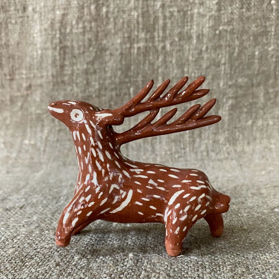 Emma Carlow pottery whistle in the shape of a reindeer against a cloth backdrop