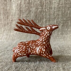 Emma Carlow pottery whistle in the shape of a reindeer against a cloth backdrop